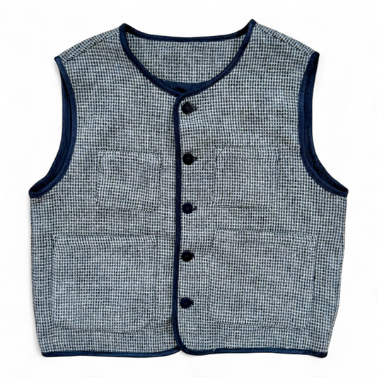 Children’s wool gilet in blue check with quilted cotton lining and patch pockets — front view.