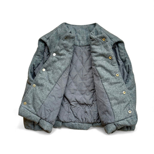 Children’s gilet showing diamond-quilted lining and hidden popper fastening — open front view.
