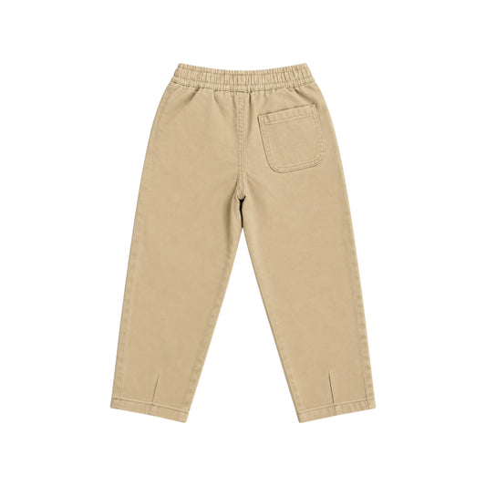 Back view of the Nyima sand cotton trousers with an elasticated waistband, single patch pocket and darted hems.