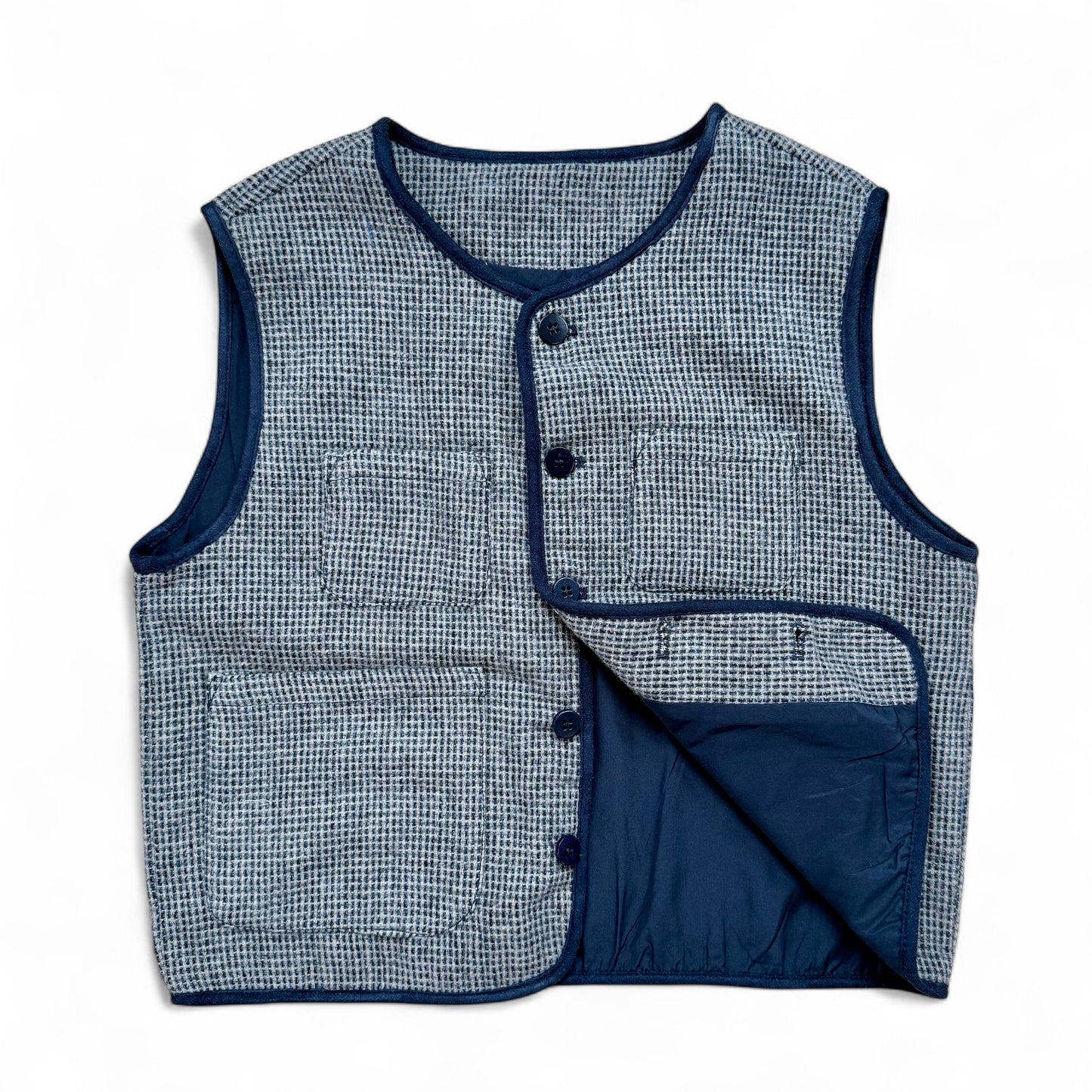 Children’s blue check wool gilet showing quilted cotton lining and patch pockets — open front view.