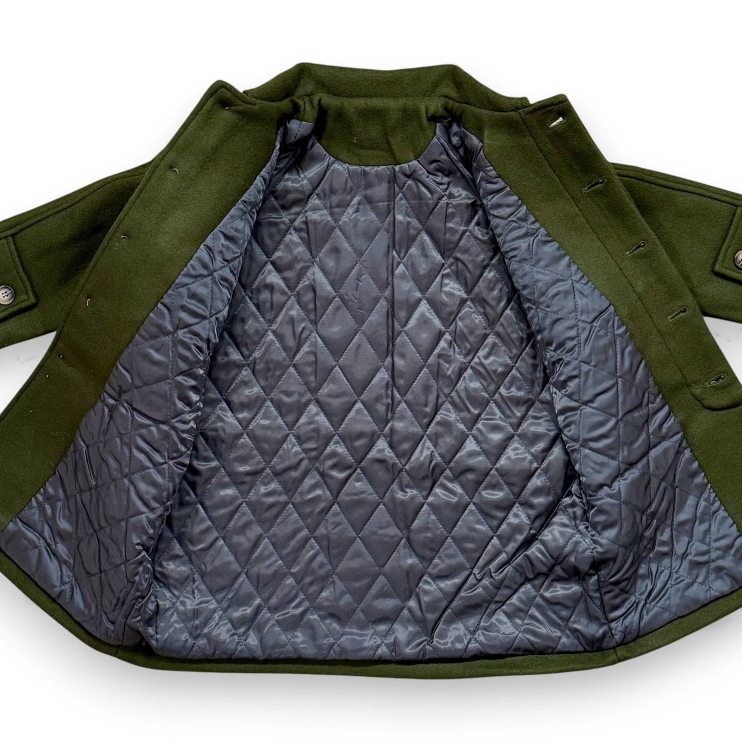 Olive boiled wool children’s pea coat with raglan sleeves, flap pockets, sleeve tabs and quilted lining.