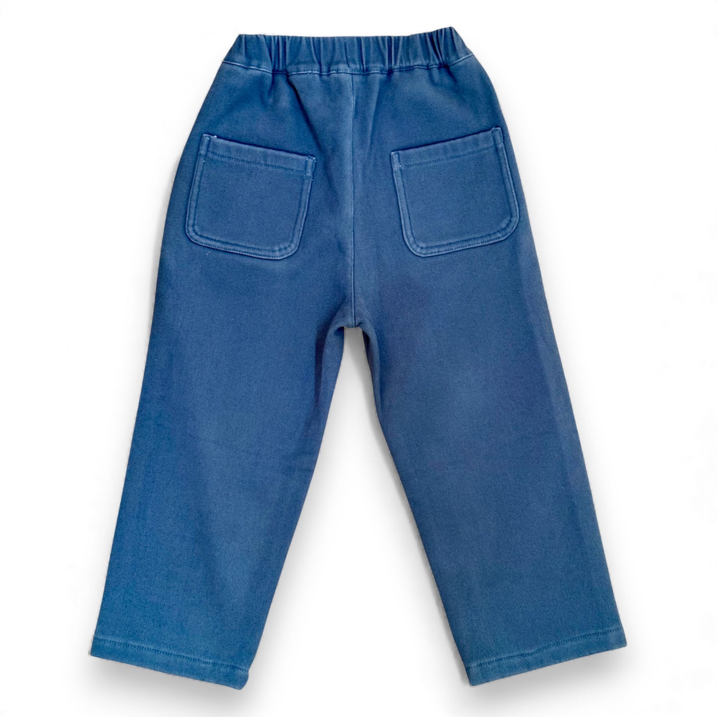 Back view of blue cotton drill Nour Pants with elasticated waistband and square patch pockets