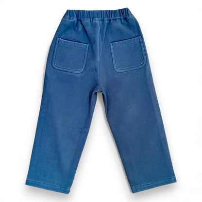Back view of blue cotton drill Nour Pants with elasticated waistband and square patch pockets