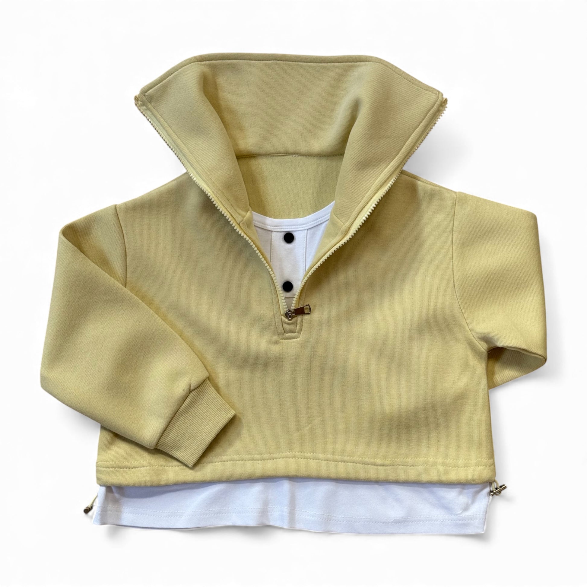 Sherbet-lemon organic cotton children’s tracksuit with funnel-neck top, mock T-shirt underlayer with drawstring, and straight-leg stitched-pleat trousers.