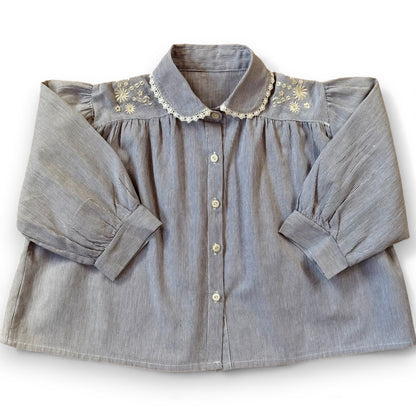 Children’s pinstripe A-line blouse with lace-trimmed Peter Pan collar, embroidery on shoulders and pleated front.