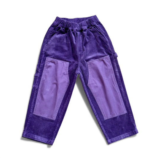 Purple corduroy children’s trousers with contrast knee patches, slant pockets and straight leg — front view.