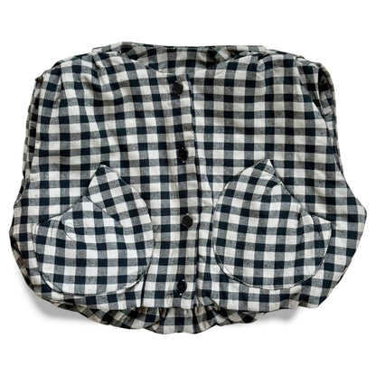 Black-and-cream gingham quilted children’s gilet with petal-shaped pockets and popper fastening.