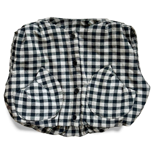 Black-and-cream gingham quilted children’s gilet with petal-shaped pockets and popper fastening.