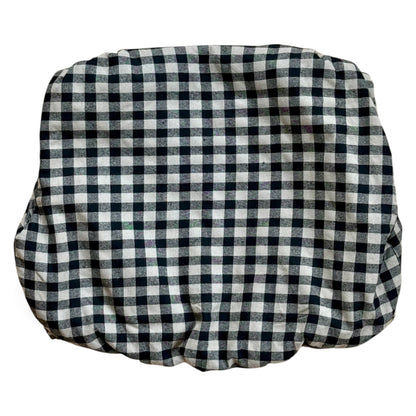 Black-and-cream gingham quilted children’s gilet with petal-shaped pockets and popper fastening.