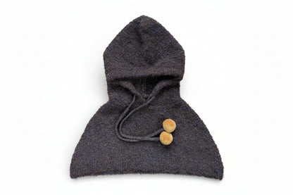 Children’s wool hooded shoulder cape in dark brown with drawstring and pom-pom ties, designed to sit on the shoulders and be worn under a coat.