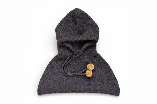 Children’s wool hooded shoulder cape in dark brown with drawstring and pom-pom ties, designed to sit on the shoulders and be worn under a coat.