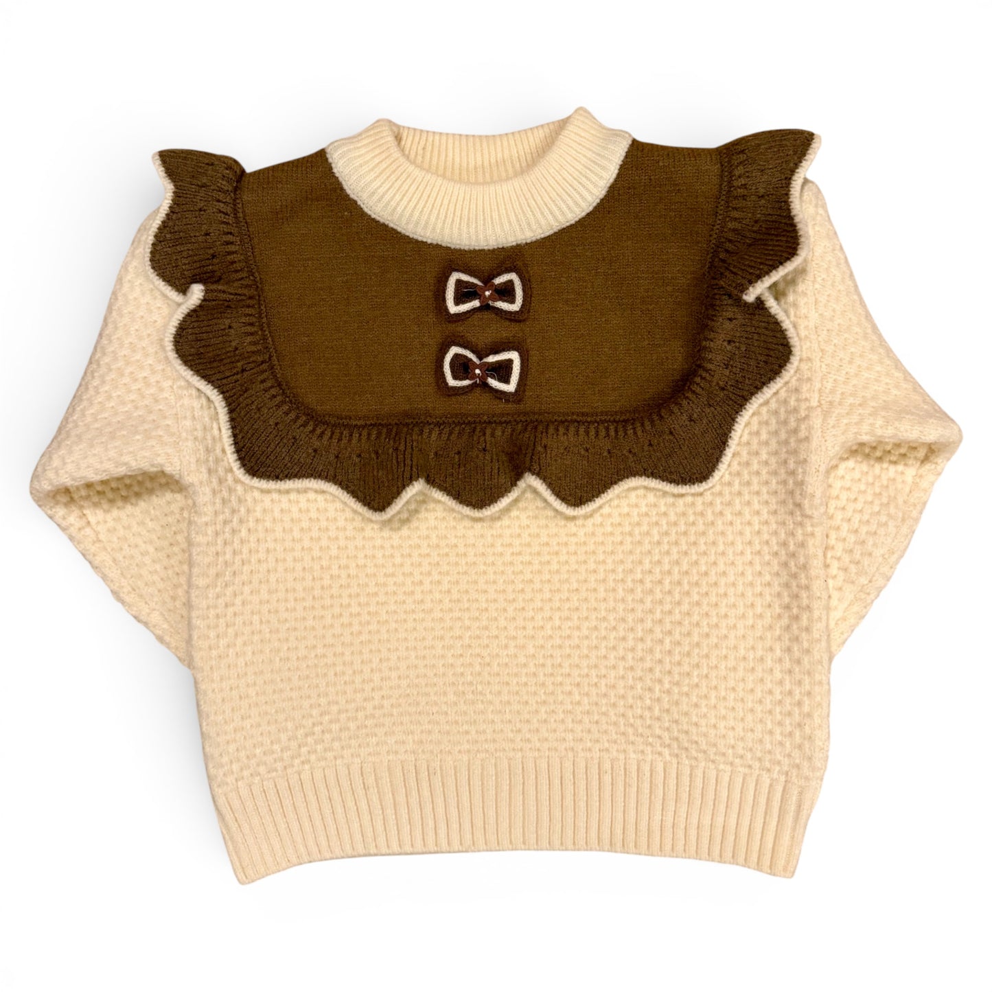 Rummie Jumper in white Victorian-inspired children’s waffle stitch knit with mock bib, frill trim and bow detailing by That’s Not Fair London. Heritage children’s knitwear 