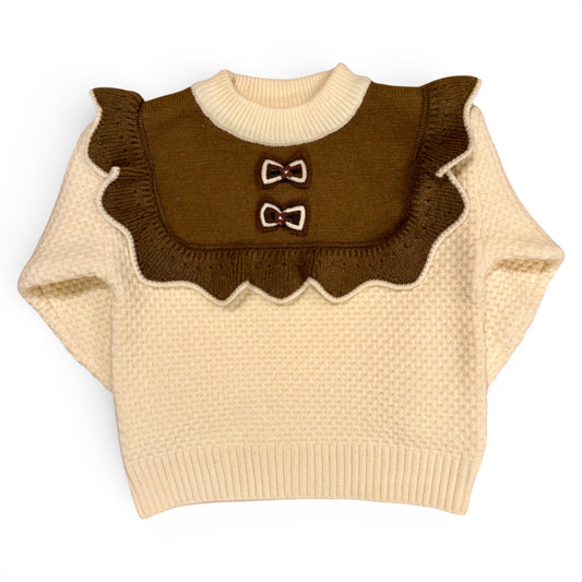 Rummie Jumper in white Victorian-inspired children’s waffle stitch knit with mock bib, frill trim and bow detailing by That’s Not Fair London. Heritage children’s knitwear 
