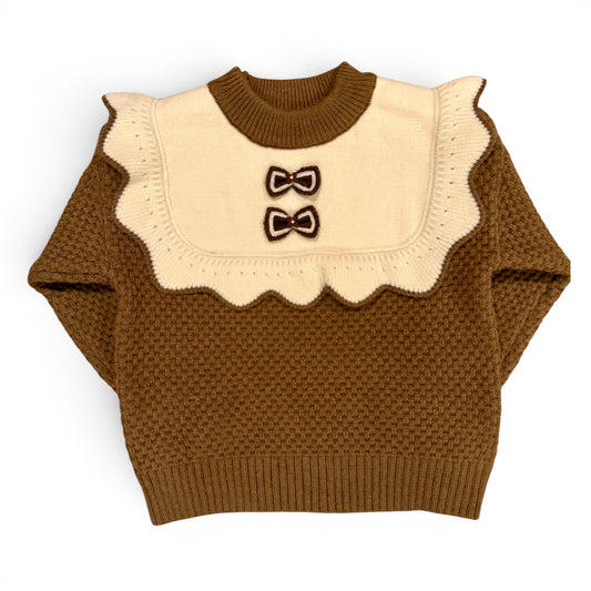 Rummie Jumper in white Victorian-inspired children’s waffle stitch knit with mock bib, frill trim and bow detailing by That’s Not Fair London. Heritage children’s knitwear  