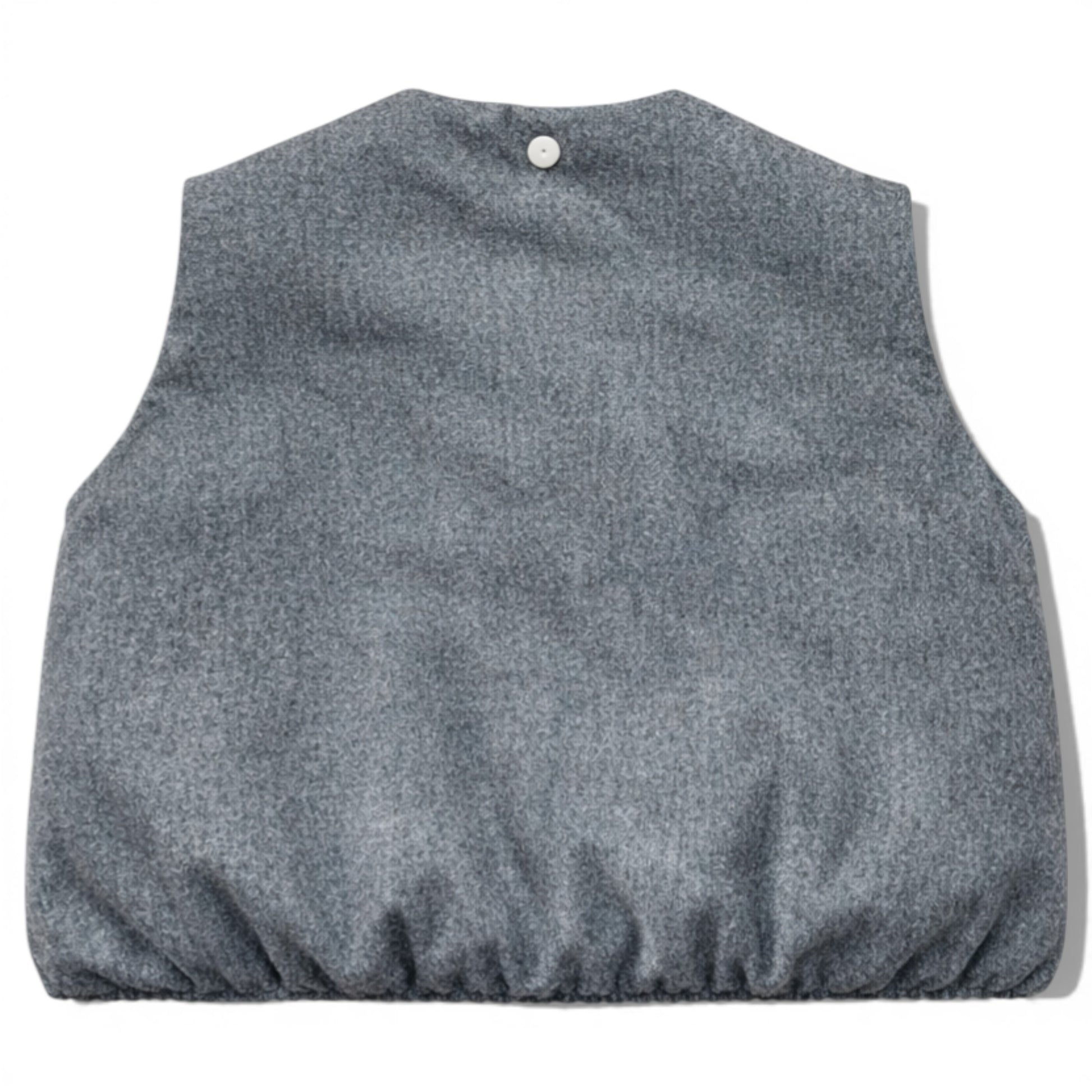 Kids grey wool sleeveless gilet with quilted interior, elastic hem and hidden popper placket. Grey wool children’s gilet cut on the bias for a swing silhouette