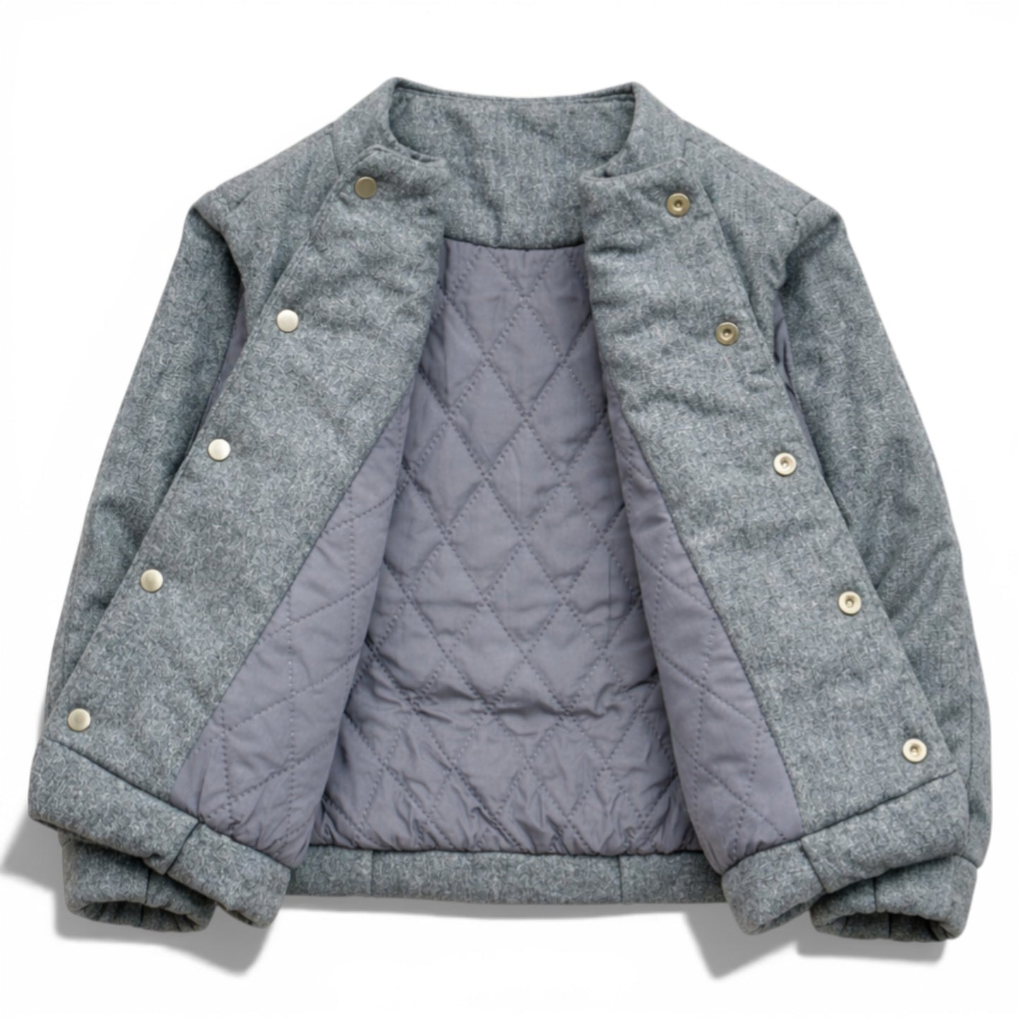 Grey wool kids jacket shown open with quilted lining, snap button placket and elastic hem. Children’s gilet showing diamond-quilted lining and hidden popper fastening 