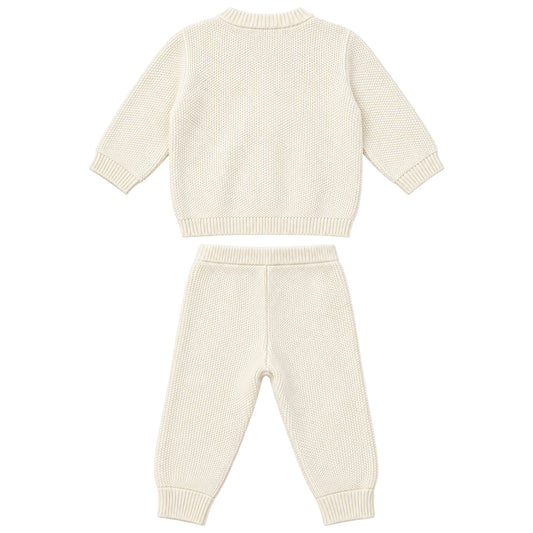 A two-piece baby knit set consisting of a long-sleeve sweater and matching jogger pants in a warm cream color, displayed flat against a solid white background.
