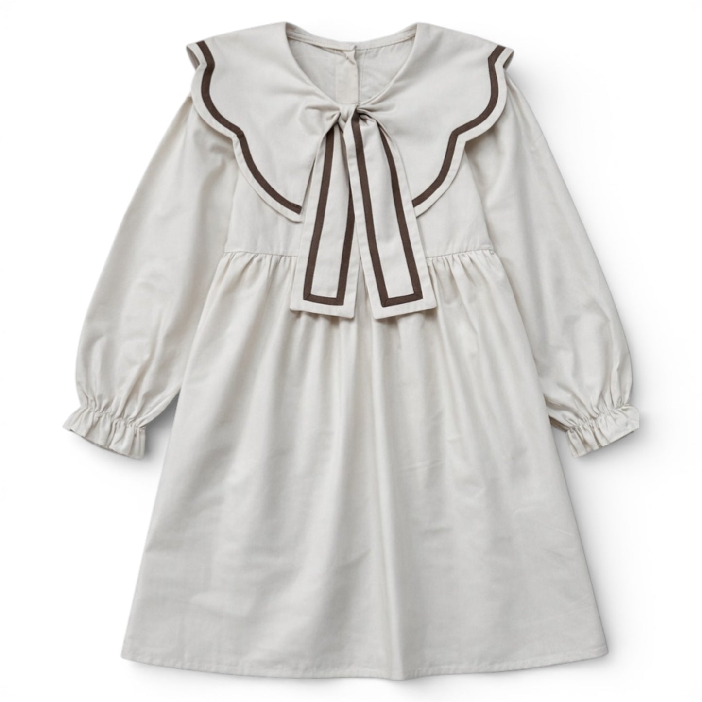 Cream empire line girls dress with scalloped contrast collar and bow detail by That’s Not Fair London.