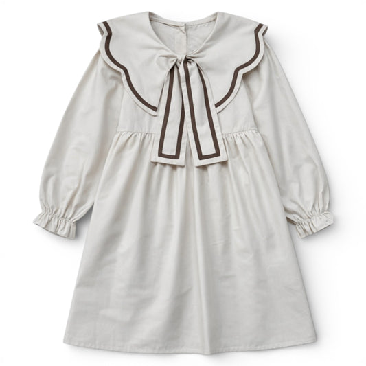 Cream empire line girls dress with scalloped contrast collar and bow detail by That’s Not Fair London.
