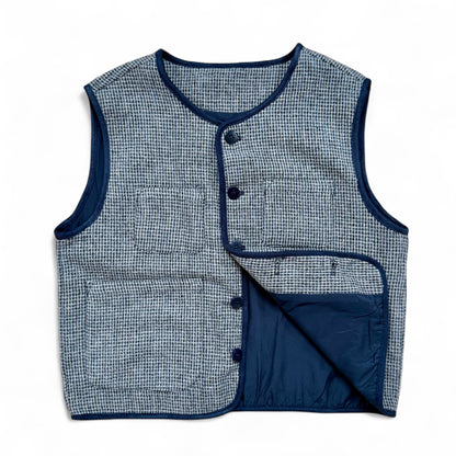 Children’s blue check wool gilet showing quilted cotton lining and patch pockets — open front view.