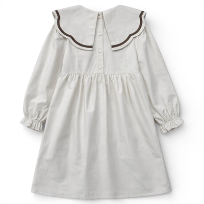 Back view of cream empire dress with split scallop collar and button fastening by That’s Not Fair London.