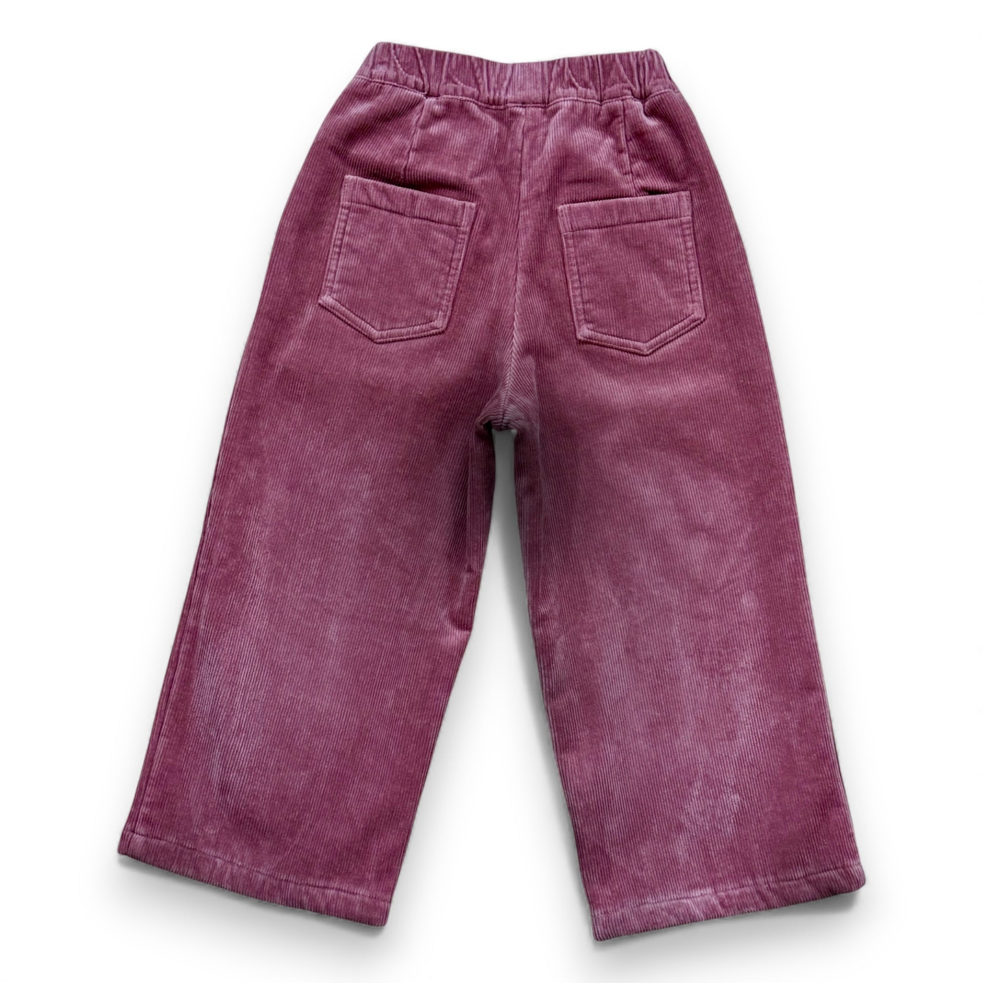 Pastel pink corduroy children’s trousers with wide leg, elastic waistband and patch pockets by That’s Not Fair London